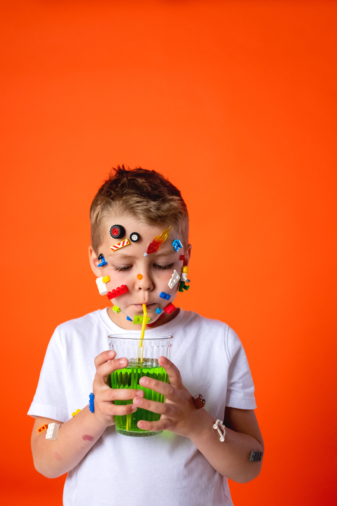 Boy in White Crew Neck T-shirt Holding Green Plastic Cup